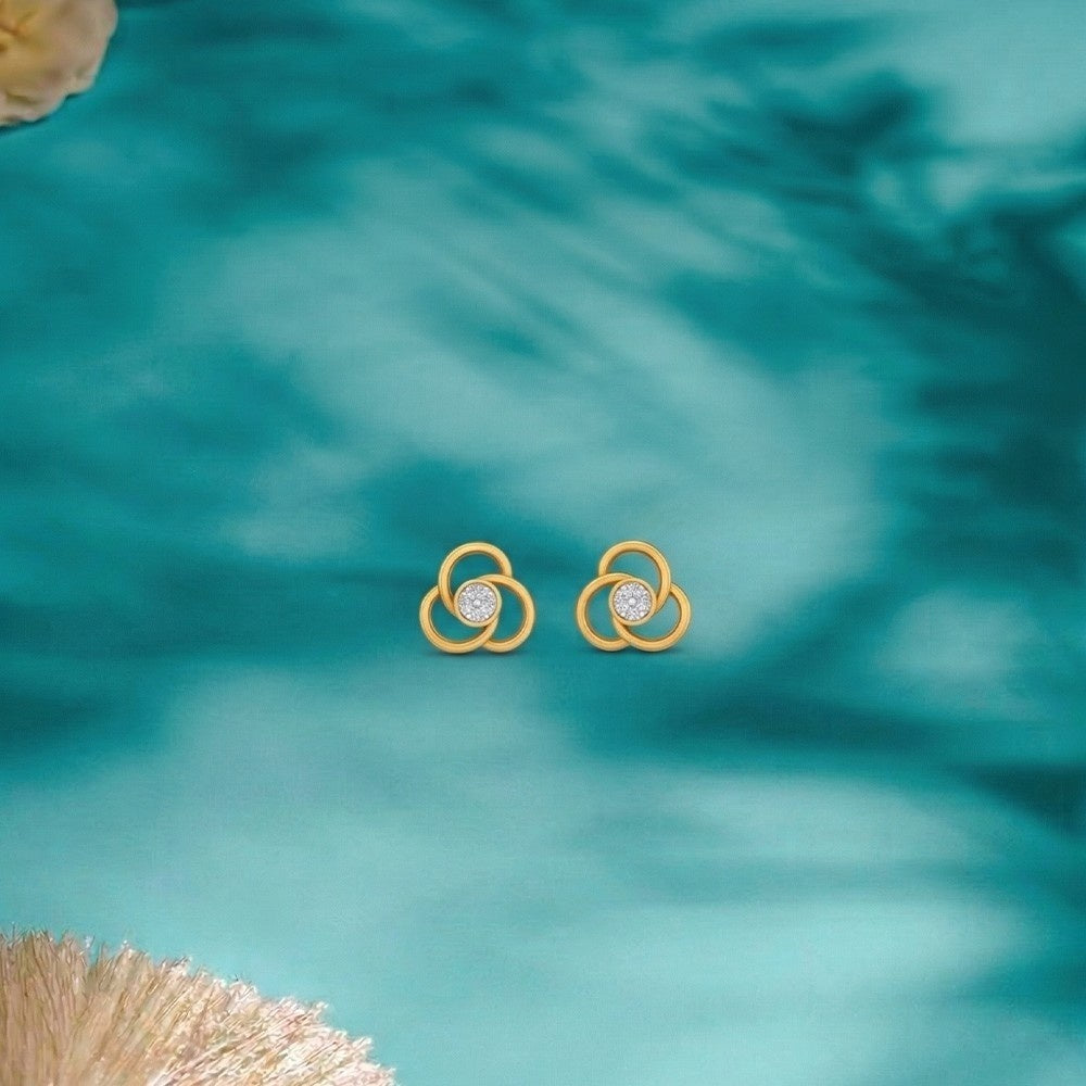 Gold and diamond floral stud on a blue surface.