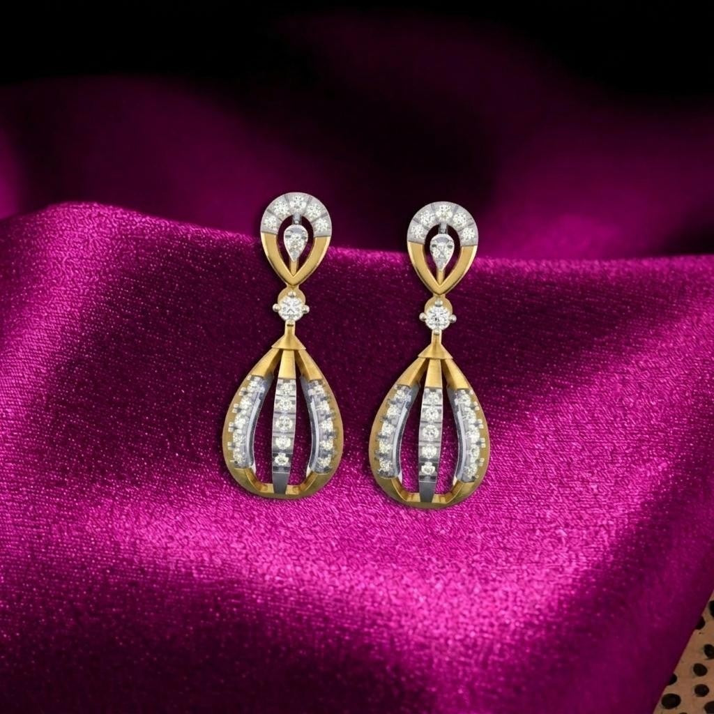 A pair of gold and diamond drop earrings displayed on a rich magenta satin fabric background.