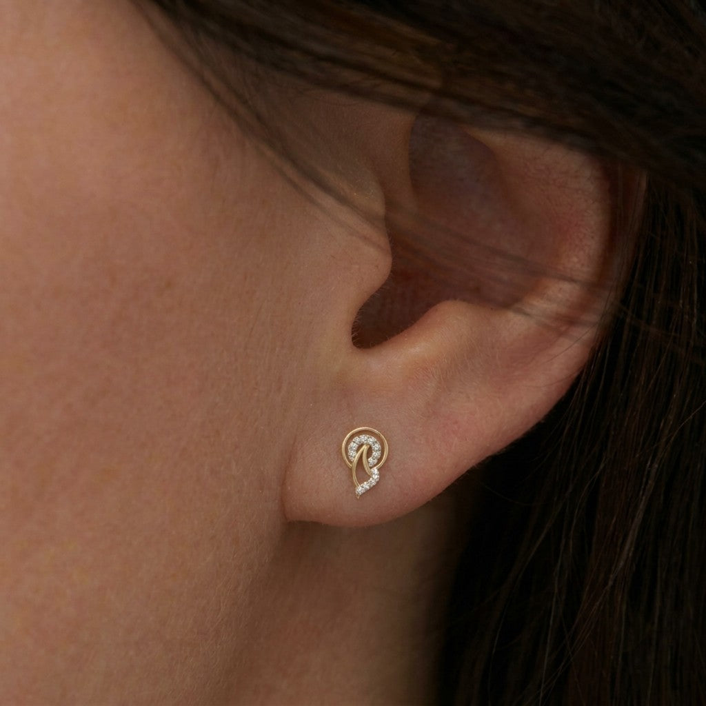 Close-up shot of a gold and diamond stud earrings.