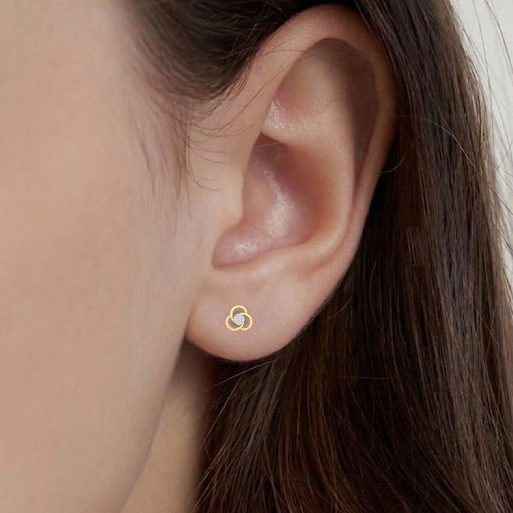 Close-up shot of a gold and diamond floral stud earring.