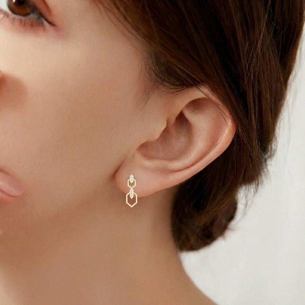 Close-up shot of a gold an diamond drop earring.