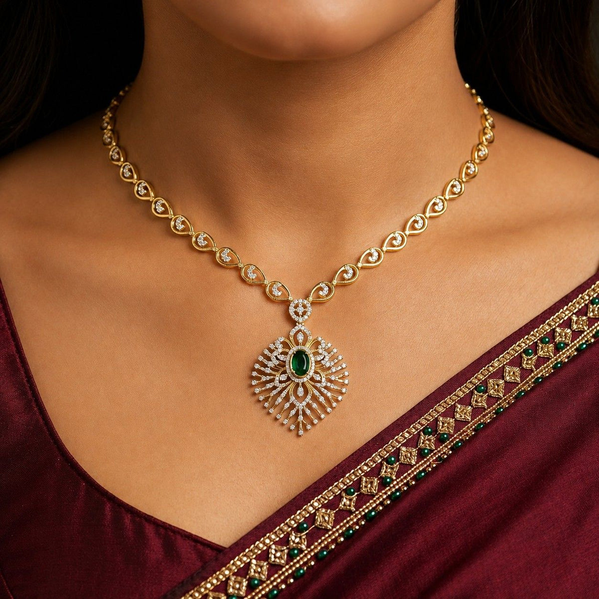Gold and diamond women wearing necklace with a green gemstone.