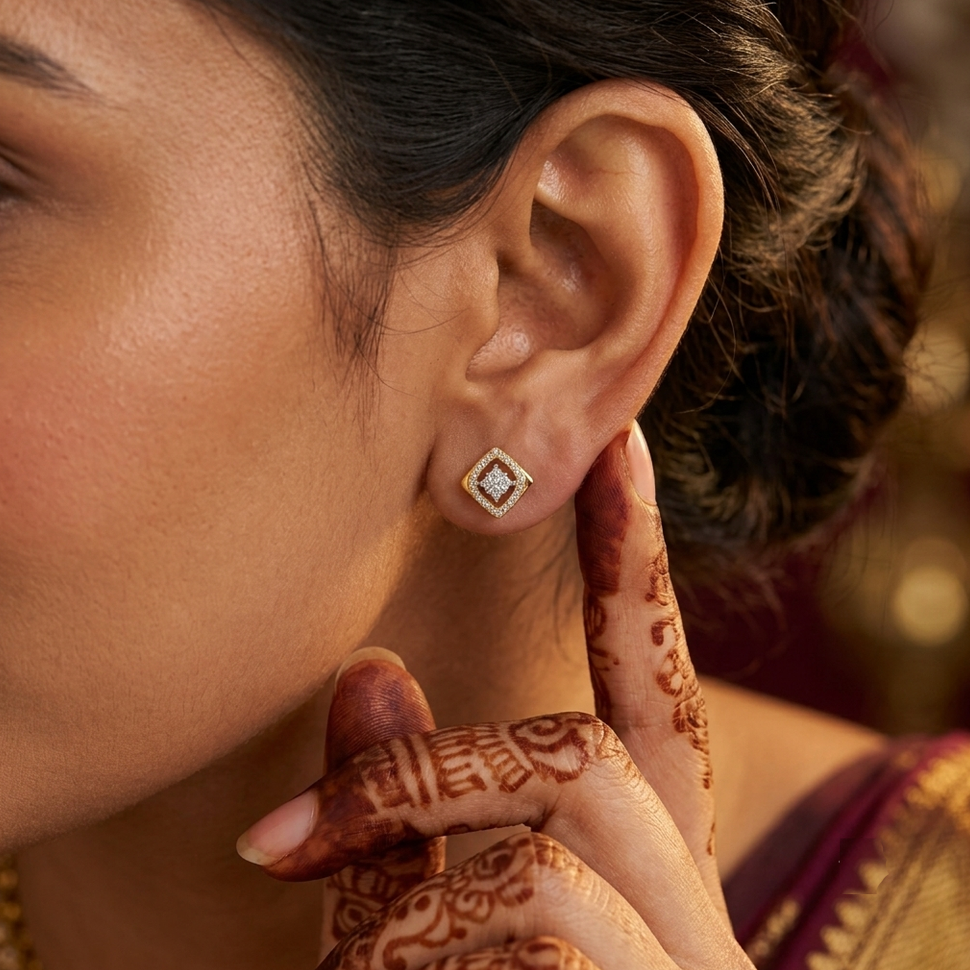 Women wearing a gold and diamond square shaped earring.