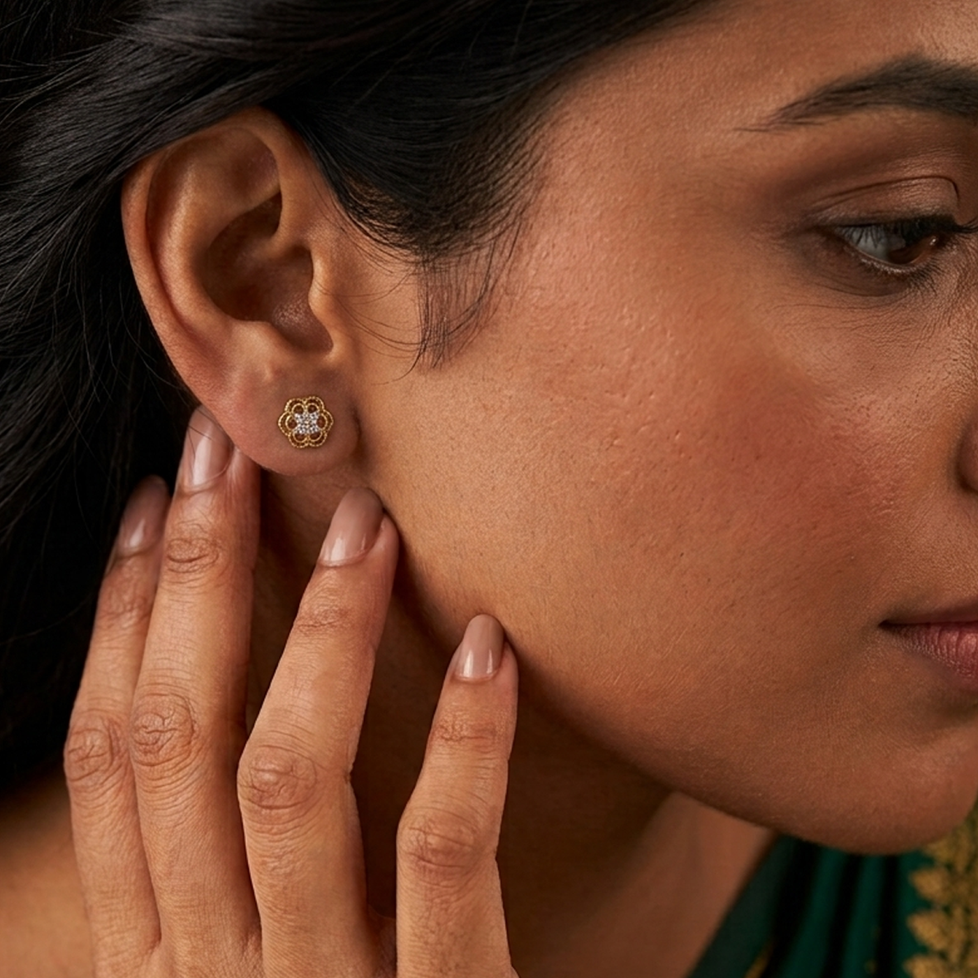 Close-up shot of a gold and diamond floral design stud earrings.