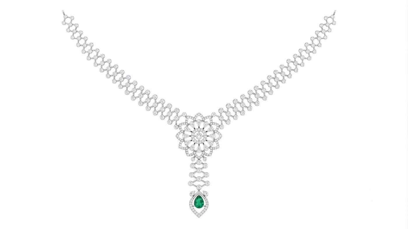 A white gold and diamond  Y-necklace featuring a central floral cluster of clear stones and a teardrop-shaped green emerald.
