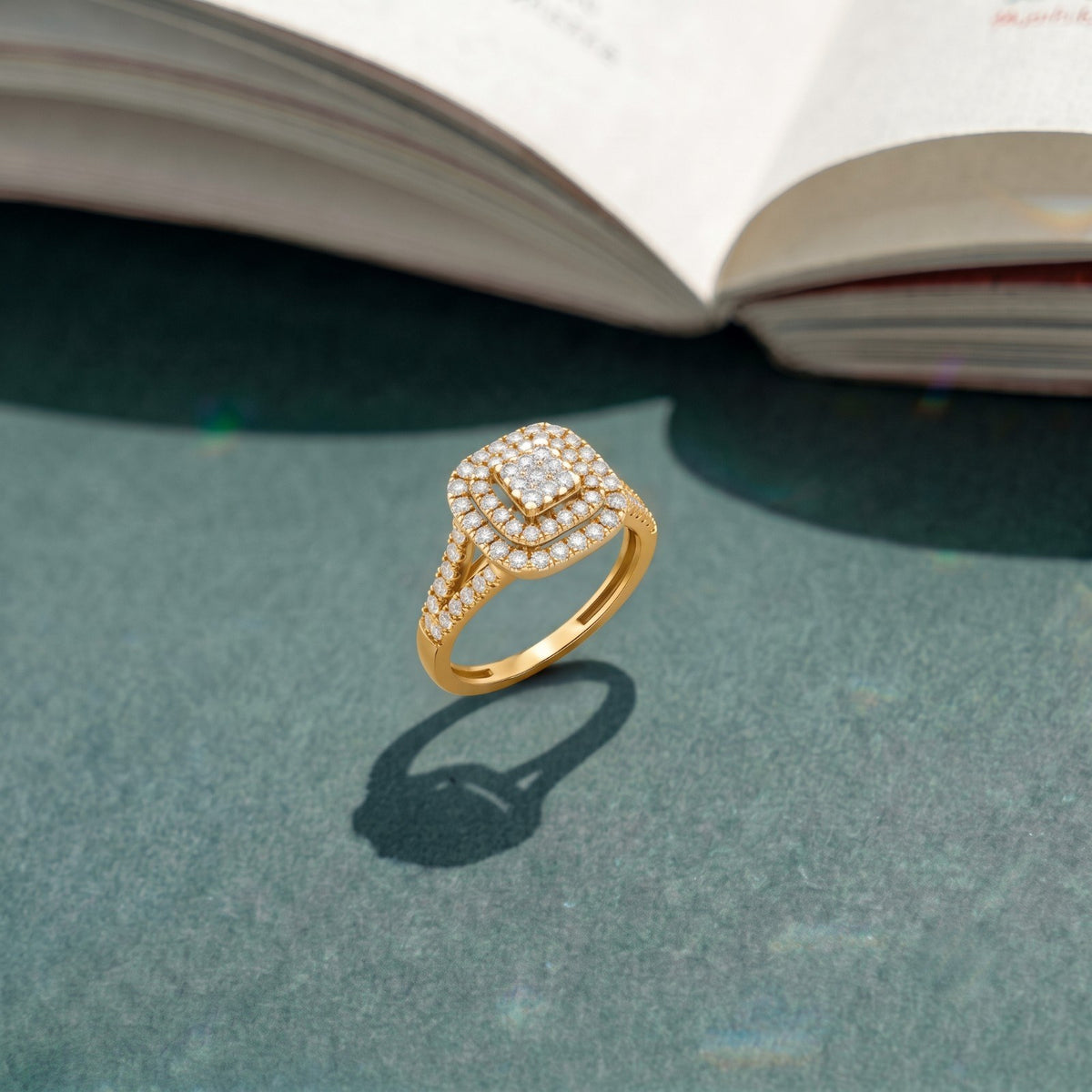 Gold ring with diamonds on a textured surface with an open book in the background