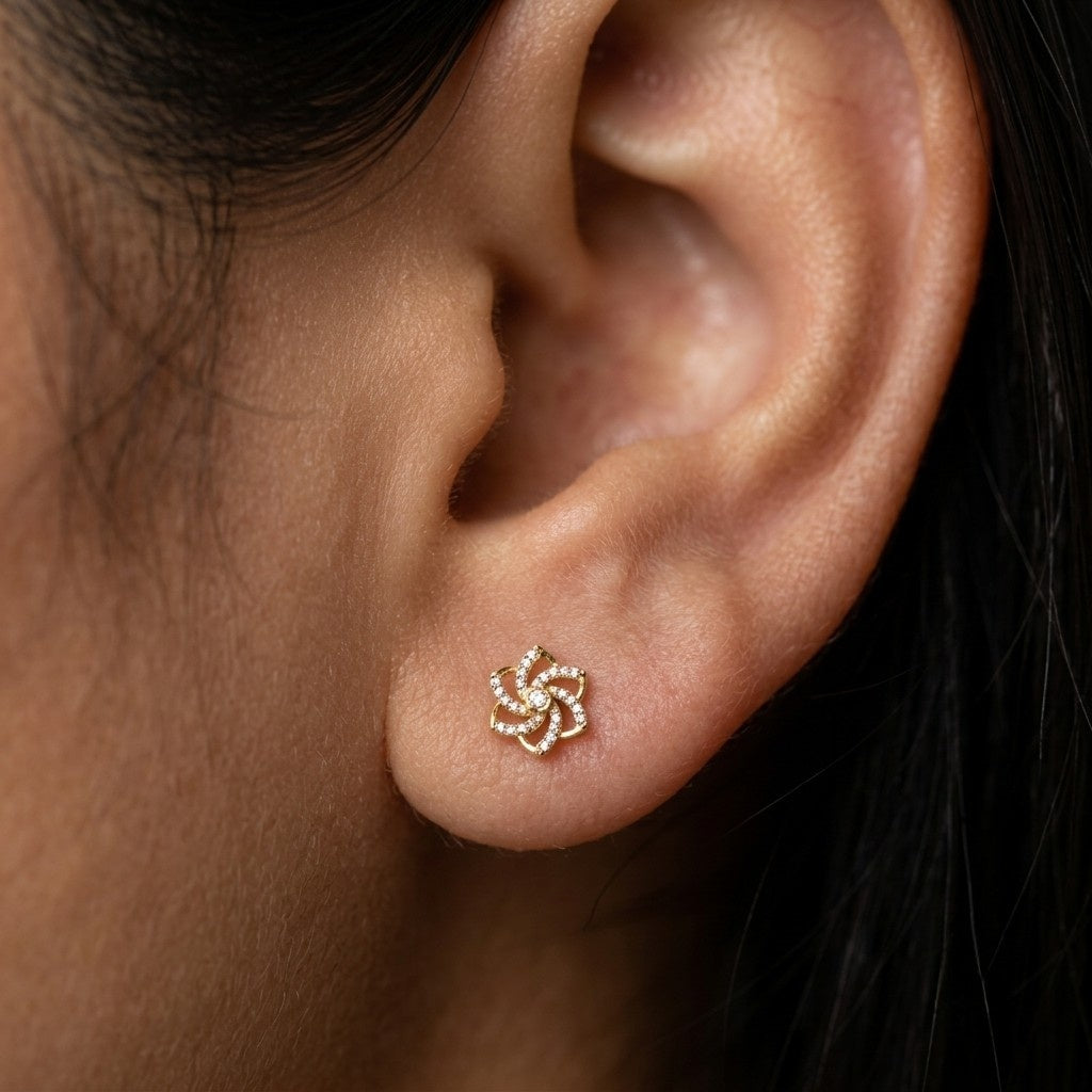 A close-up of a person's ear wearing a small gold stud earring.
