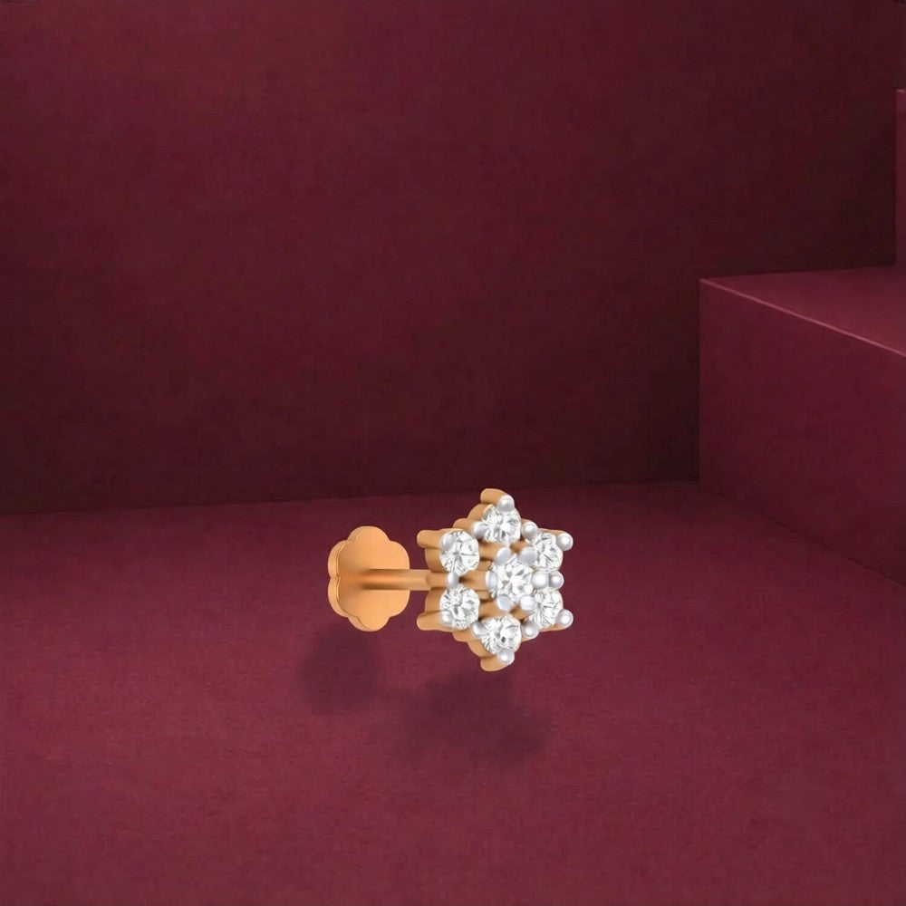 Gold and diamond stud nose pin on a red background