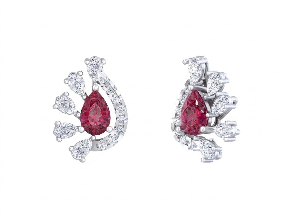 Pair of earrings with red gemstones and white gold and diamond accents on a white background