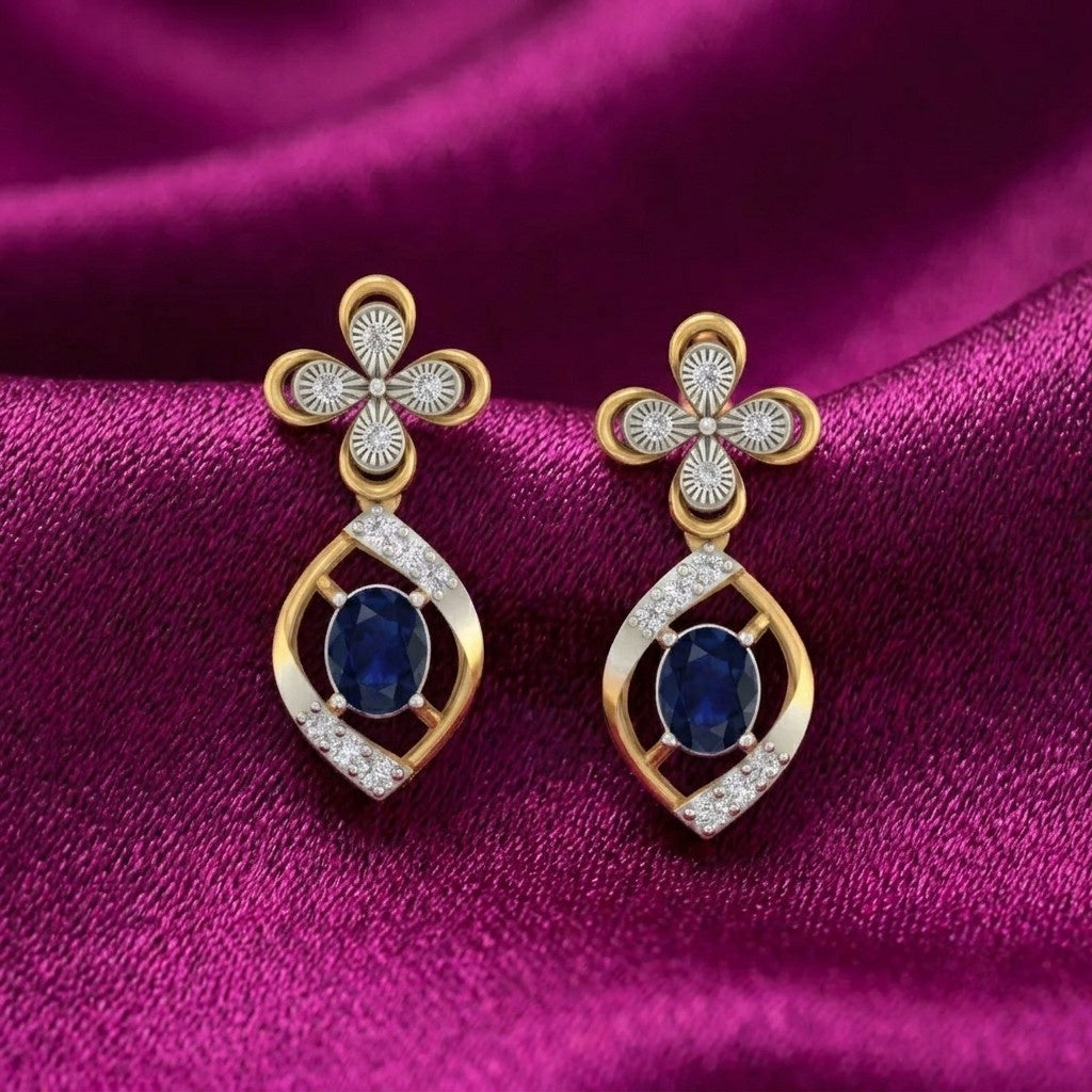 Gold and diamond drop earrings with sapphiare gemstones on a magenta fabric background.