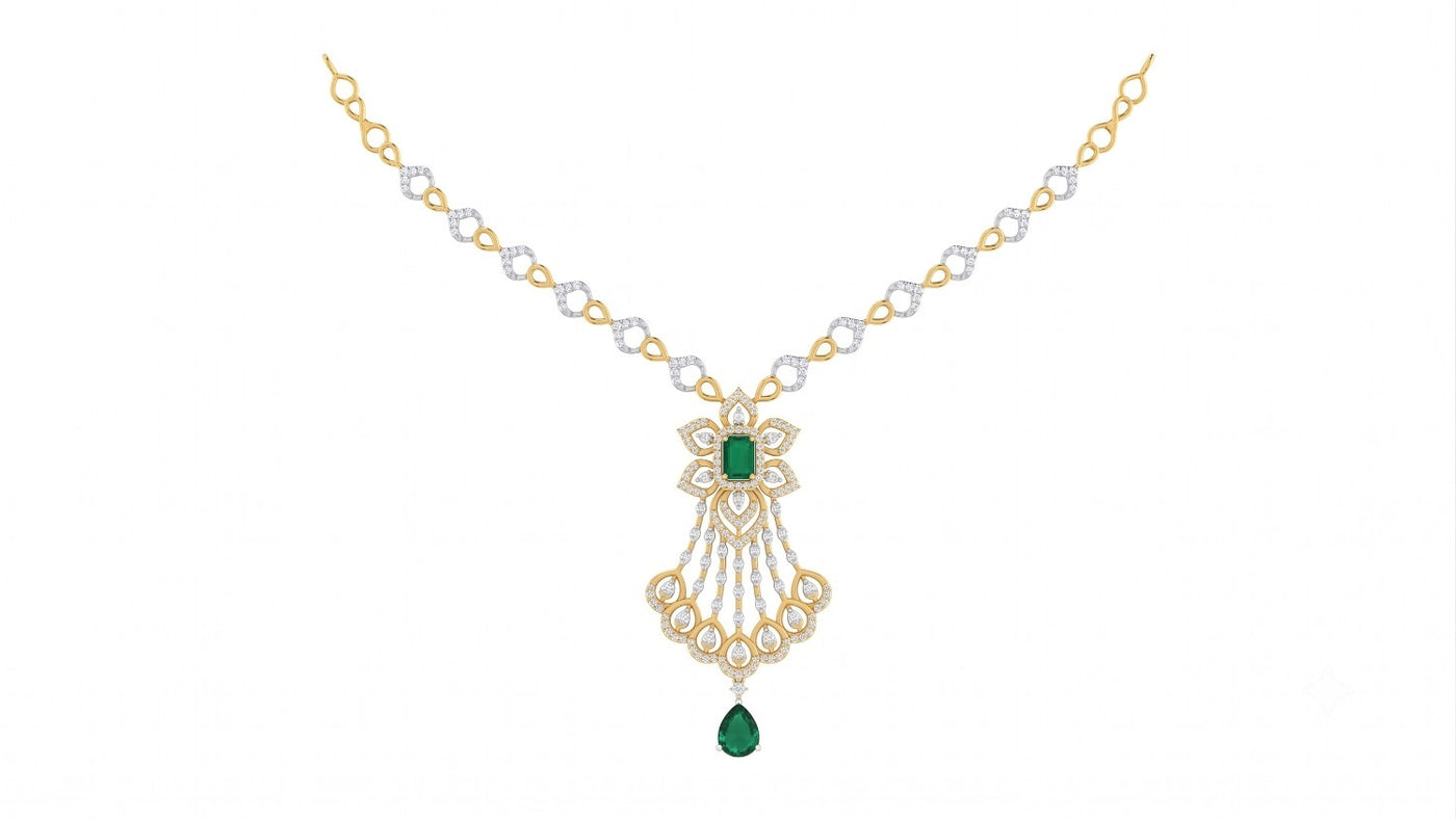 A yellow gold and diamond necklace with a central floral design featuring green emerald-cut gemstones shown on a plain white background.