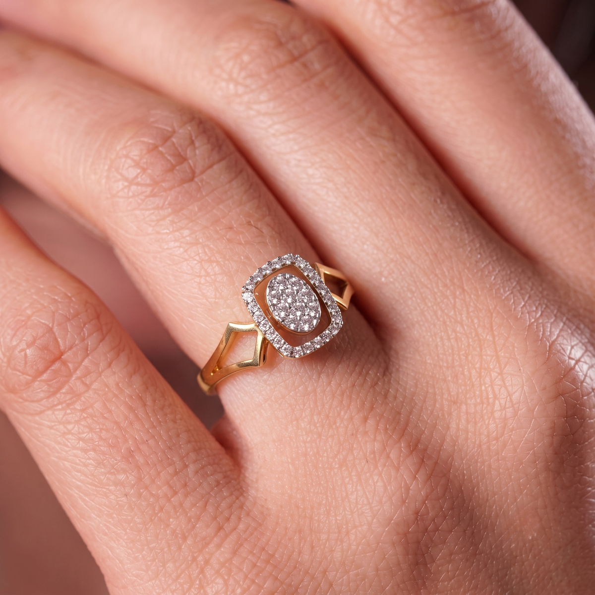 Gold ring with a diamond on a person's finger.