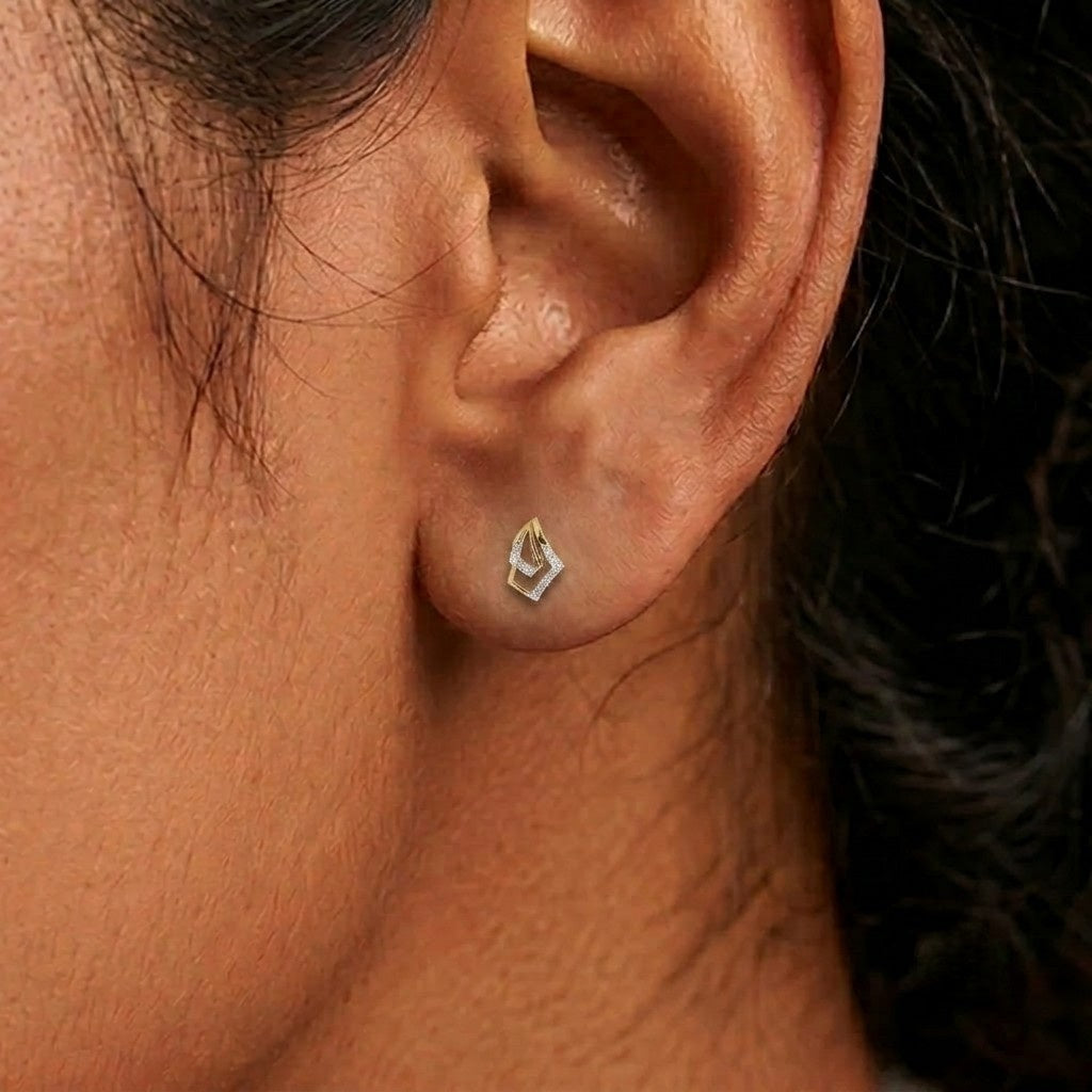 Cose-up shot of a gold and diamond stud earrings.