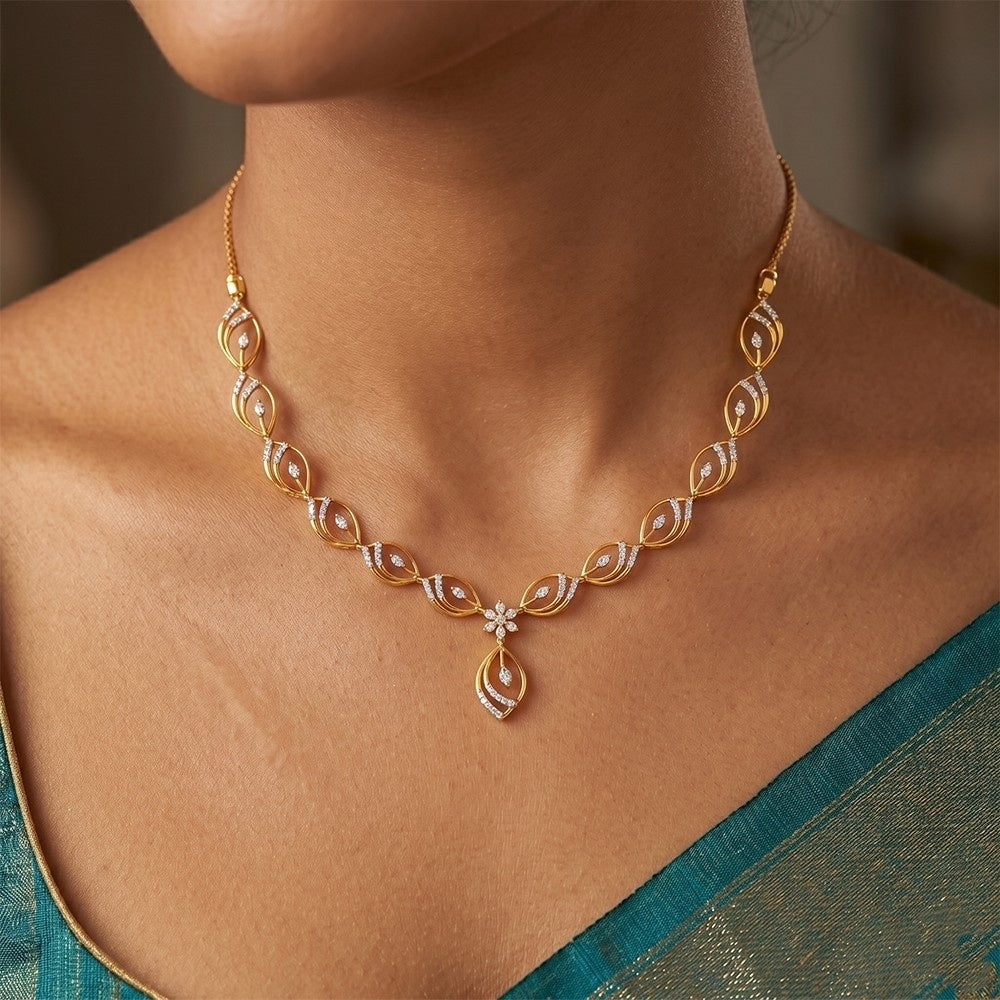 Gold and diamond necklace with a floral pendant on a person wearing a teal saree.