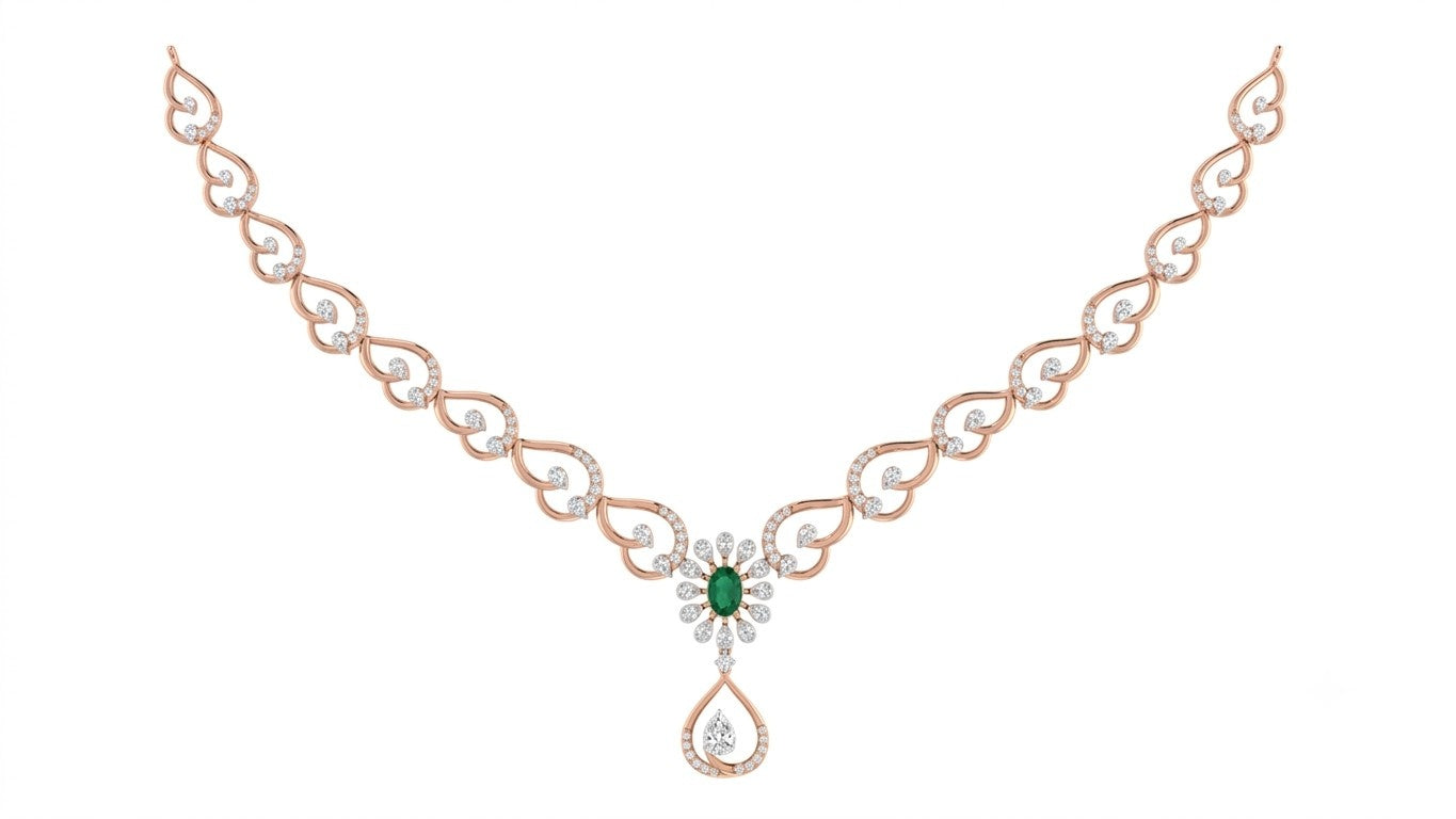 Rose gold necklace with a central green emerald and diamond floral motif, featuring a teardrop-shaped diamond, set against a plain white background.