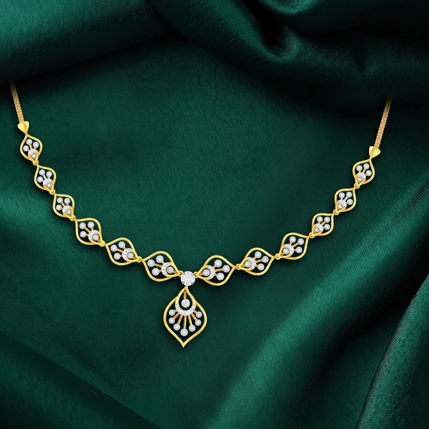 Gold necklace with diamonds on a green fabric background.