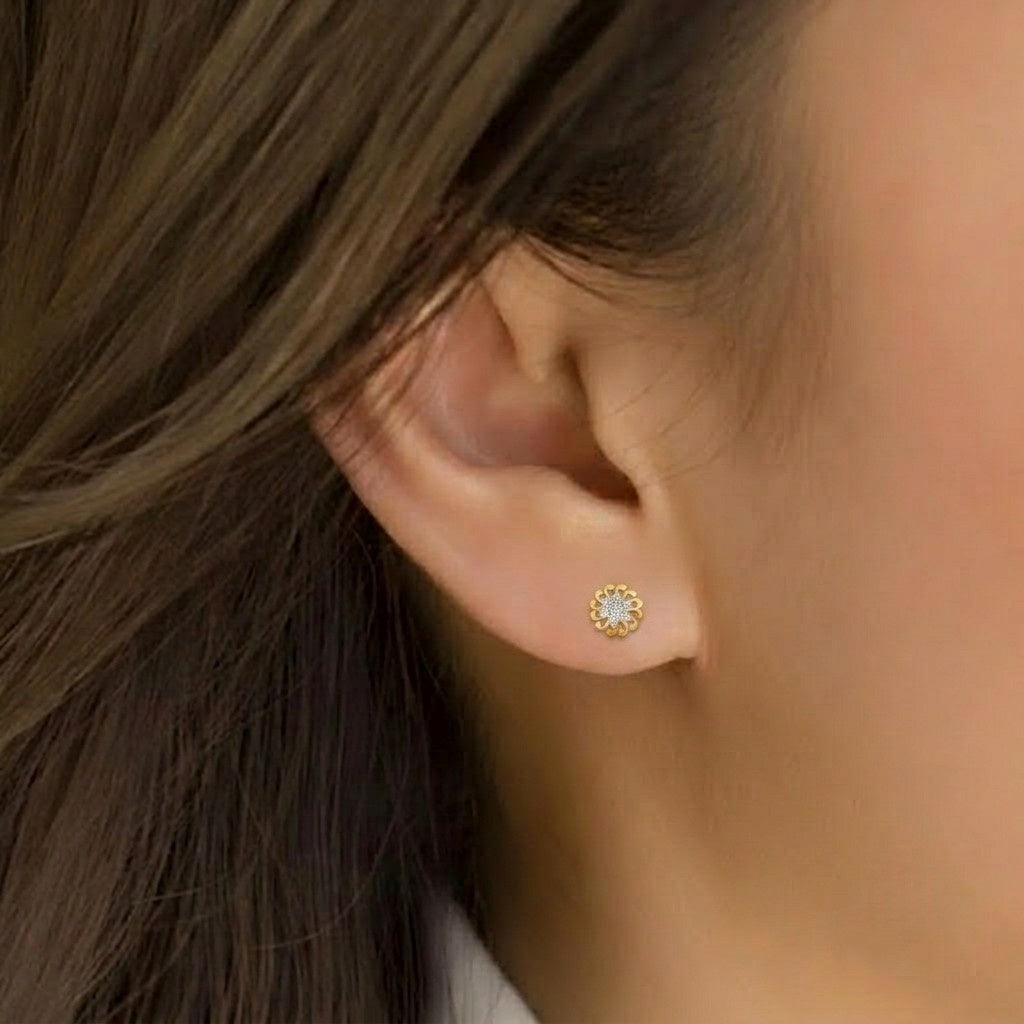 Close-up shot of a gold and diamond floral stud earring.