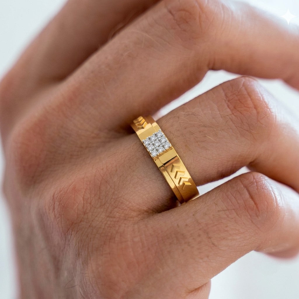 Gold ring with diamond accents on a person's finger against a white background.