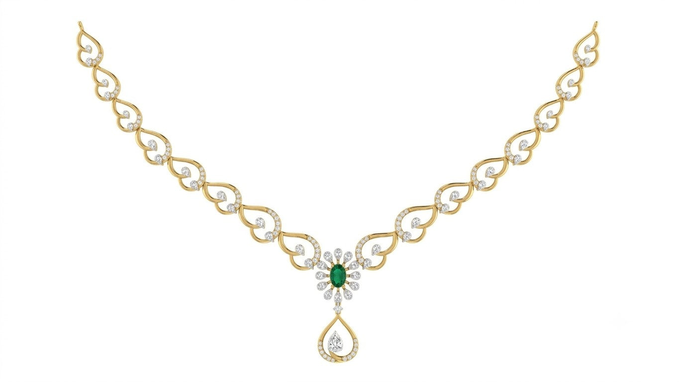 Yellow gold necklace with a central green emerald and diamond floral motif, featuring a teardrop-shaped diamond, set against a plain white background.