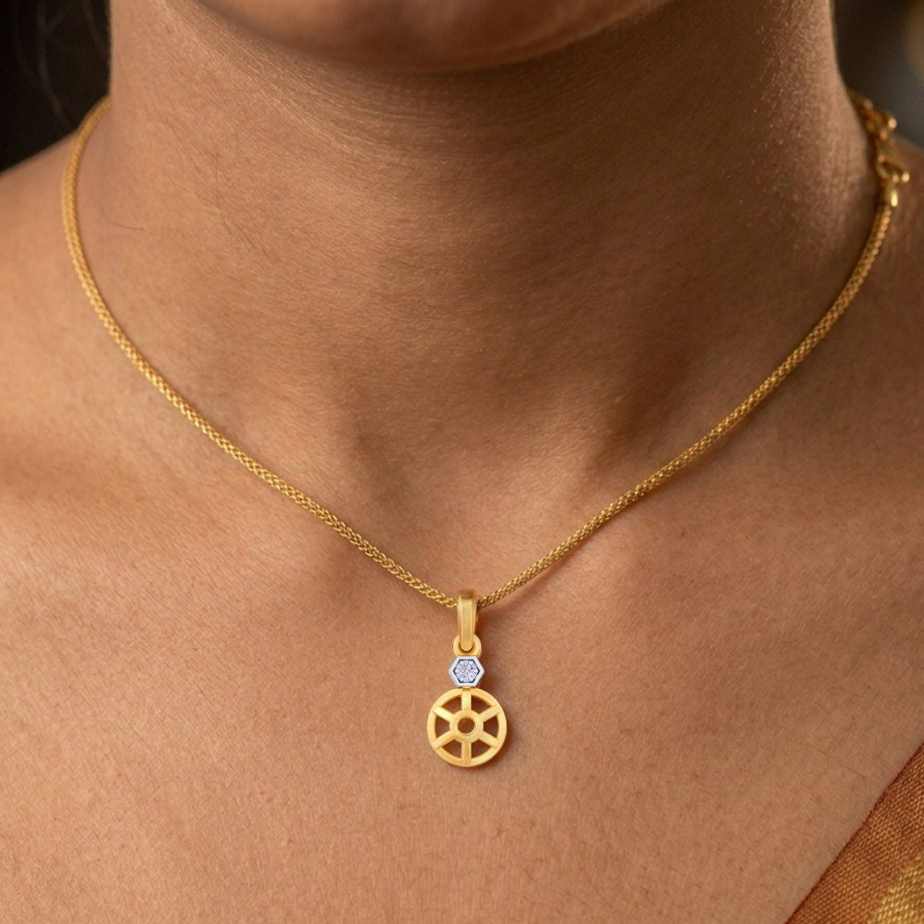 Gold necklace with a pendant on a person's neck