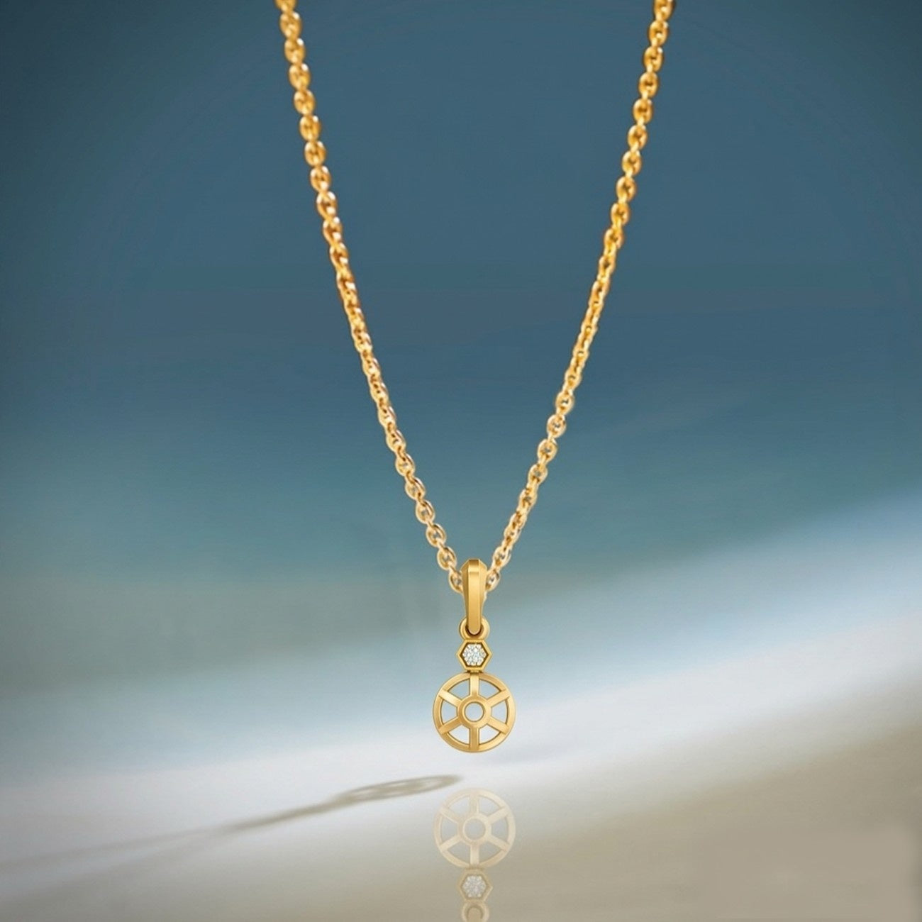 Gold necklace with a unique pendant on a gradient blue and gray background