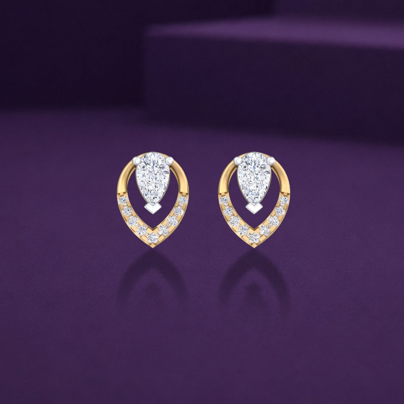 Pair of gold and diamond earrings on a reflective background.