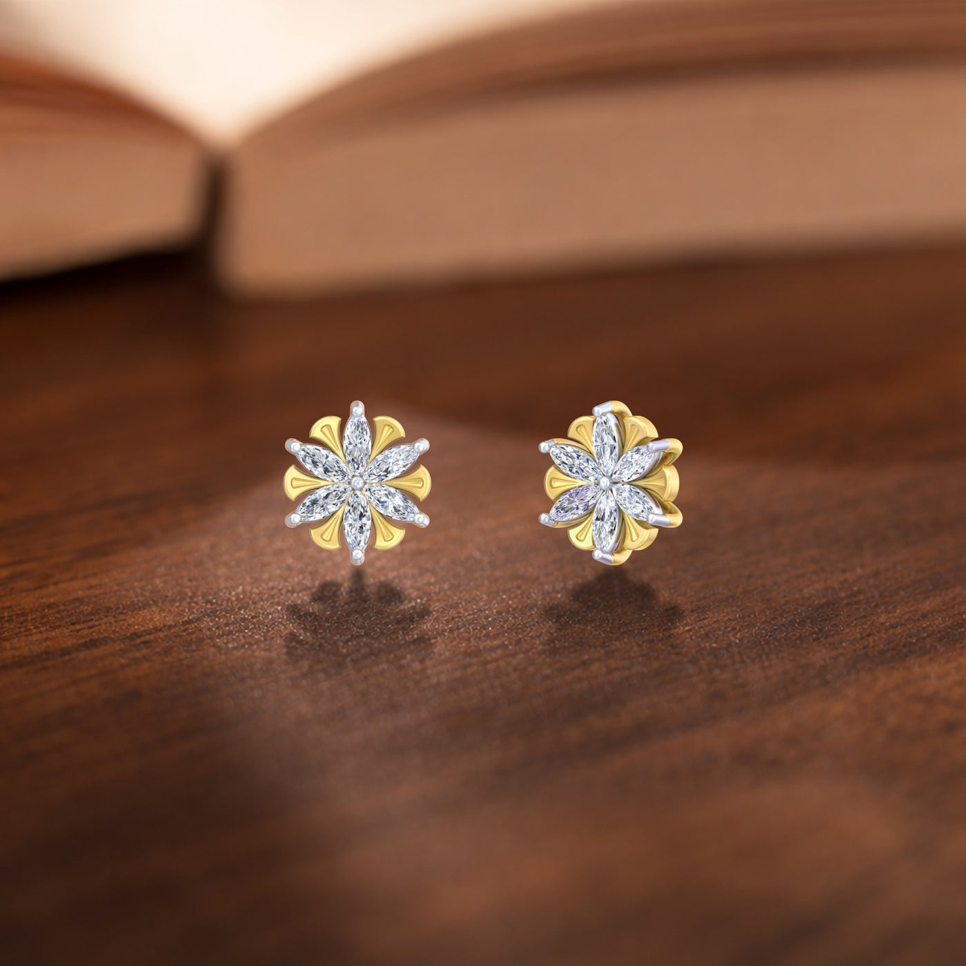 Pair of gold and diamond floral-shaped stud earrings on a wooden surface.