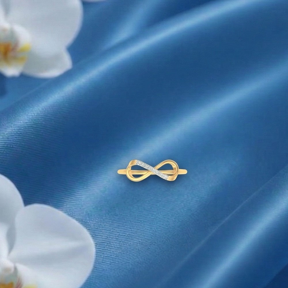 Gold ring with a unique design on a blue satin background with white flowers.