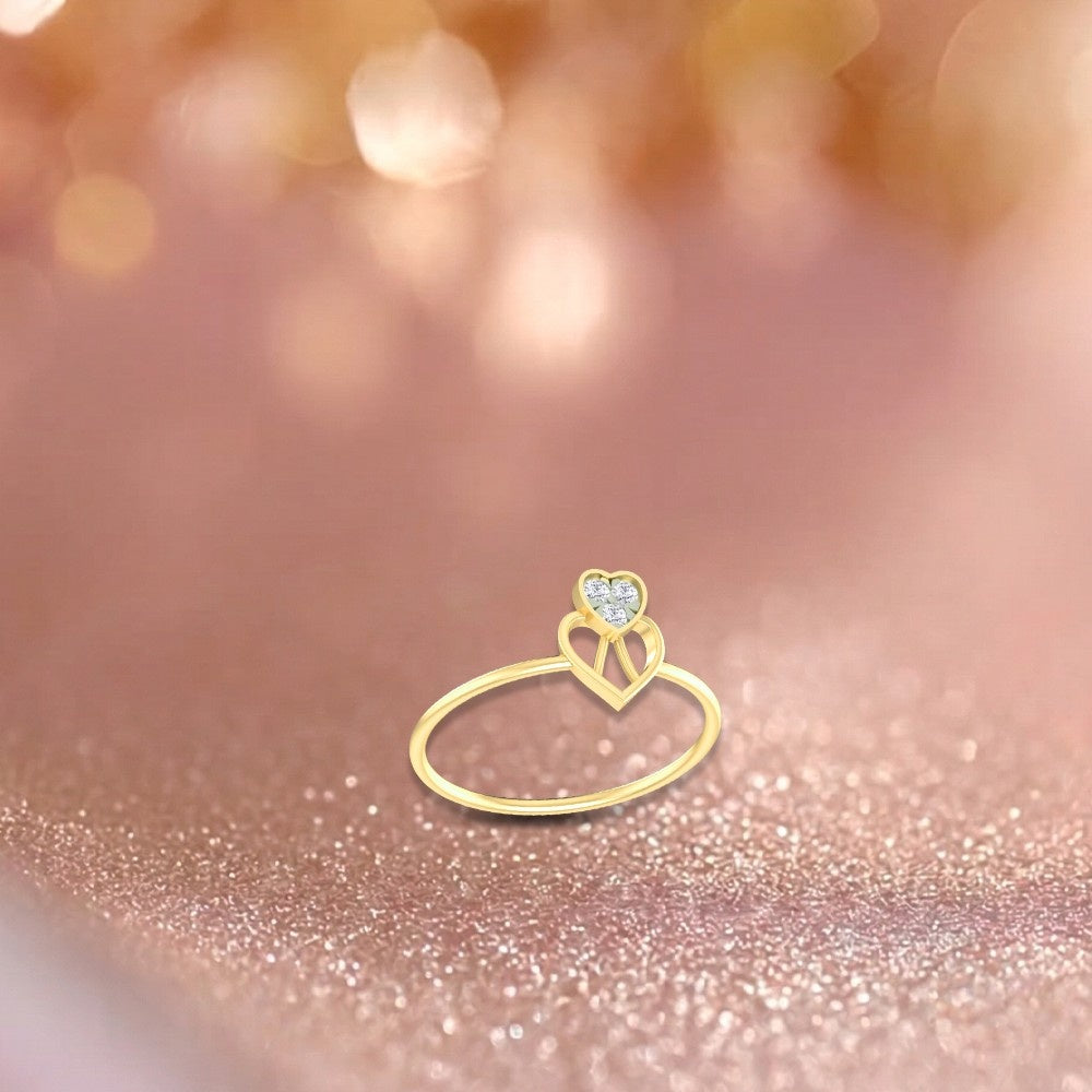 Gold ring with a heart-shaped diamond on a glittery surface