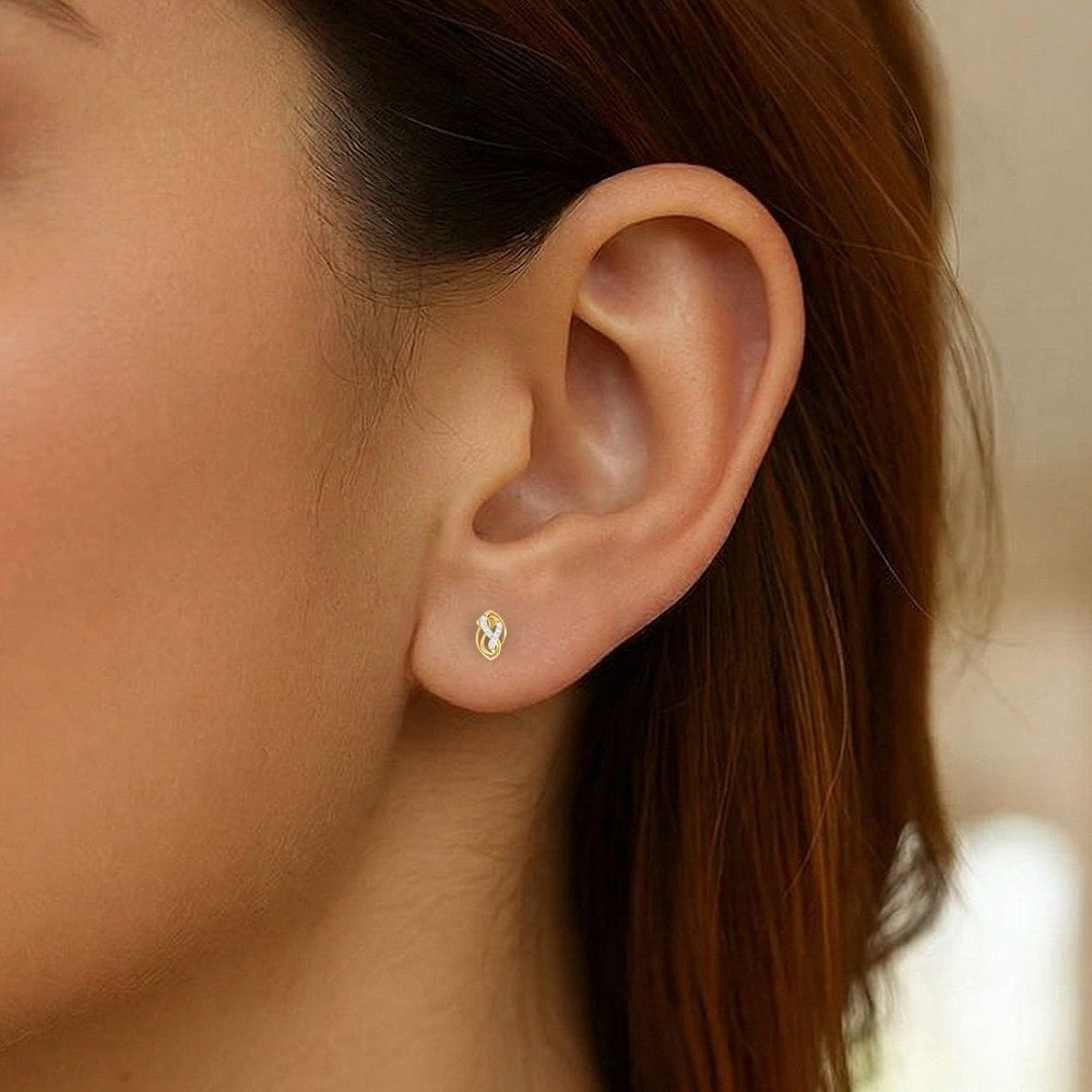 Close-up of an ear with a gold and diamond stud earring. 