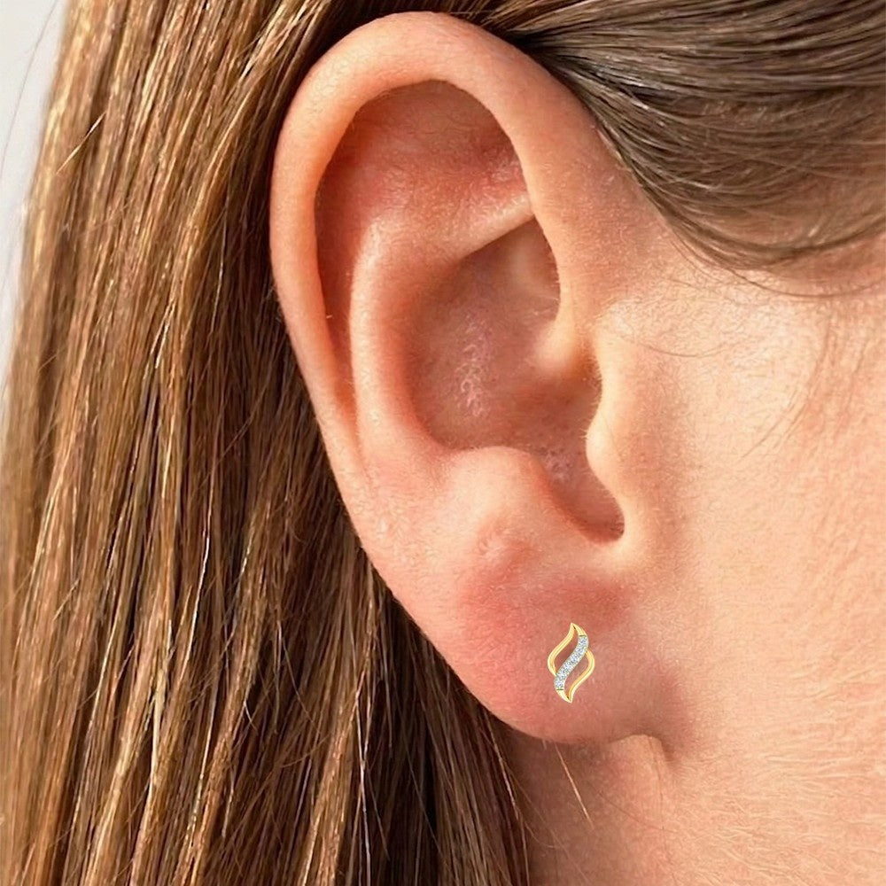 Close-up of an ear wearing a gold and diamond swirl curve stud earring.