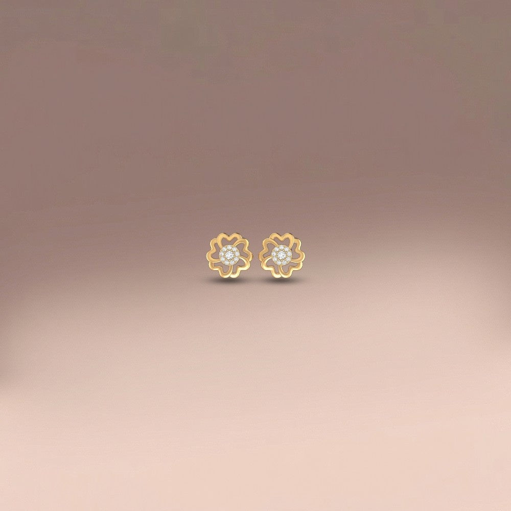 Gold and diamond floral stud earrings  on a gradient background.