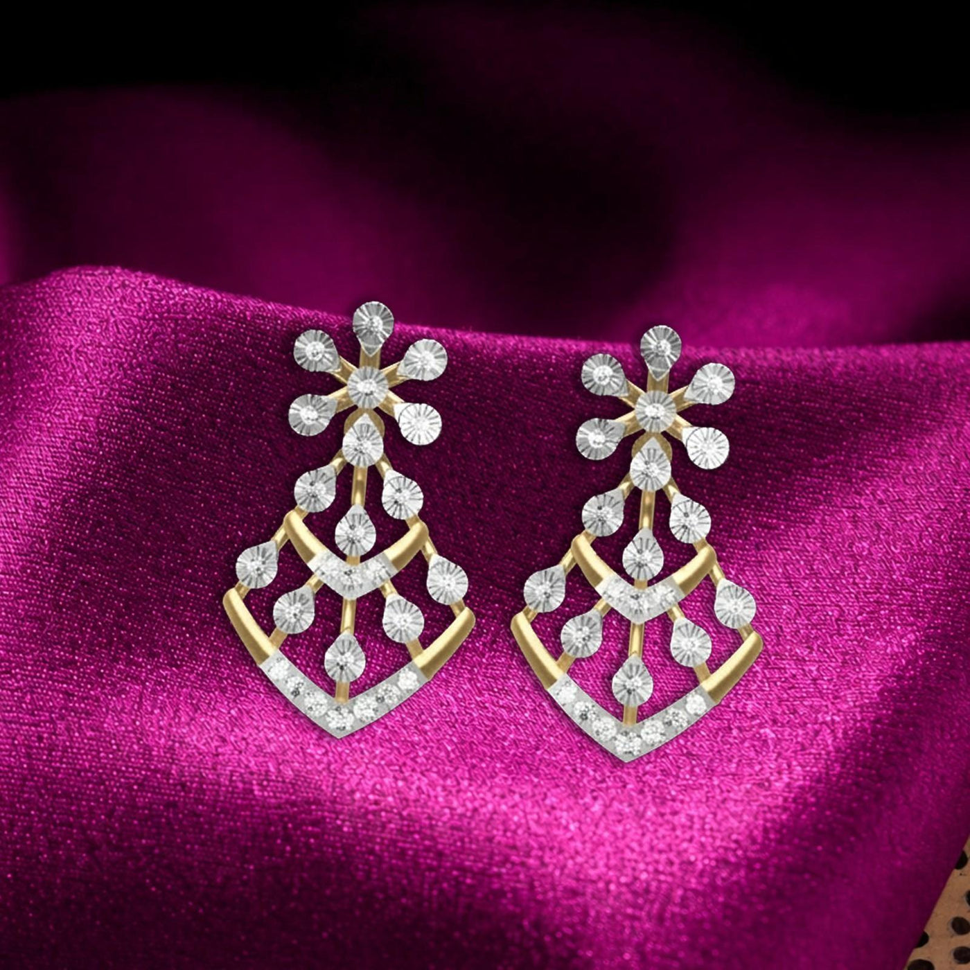 Pair of gold earrings with floral-design, displayed on a rich magenta satin fabric background.