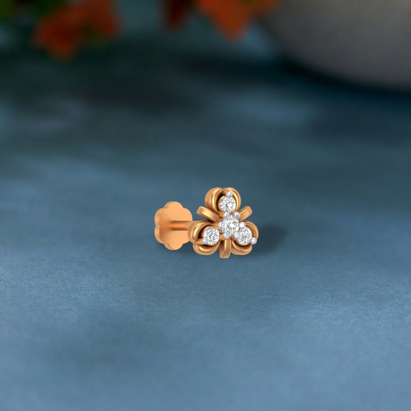 Gold and diamond stud nosepin on a blue background