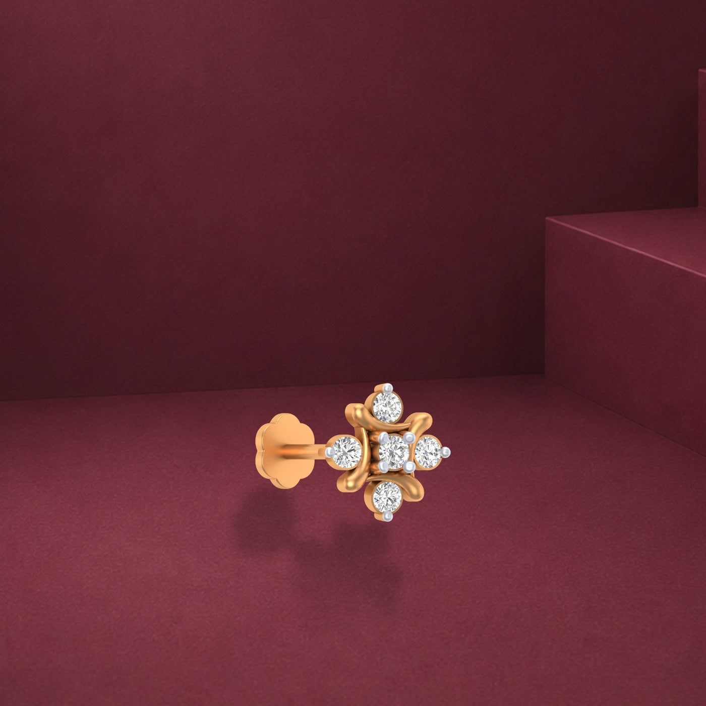 Gold and diamond stud nosepin with diamonds on a maroon background