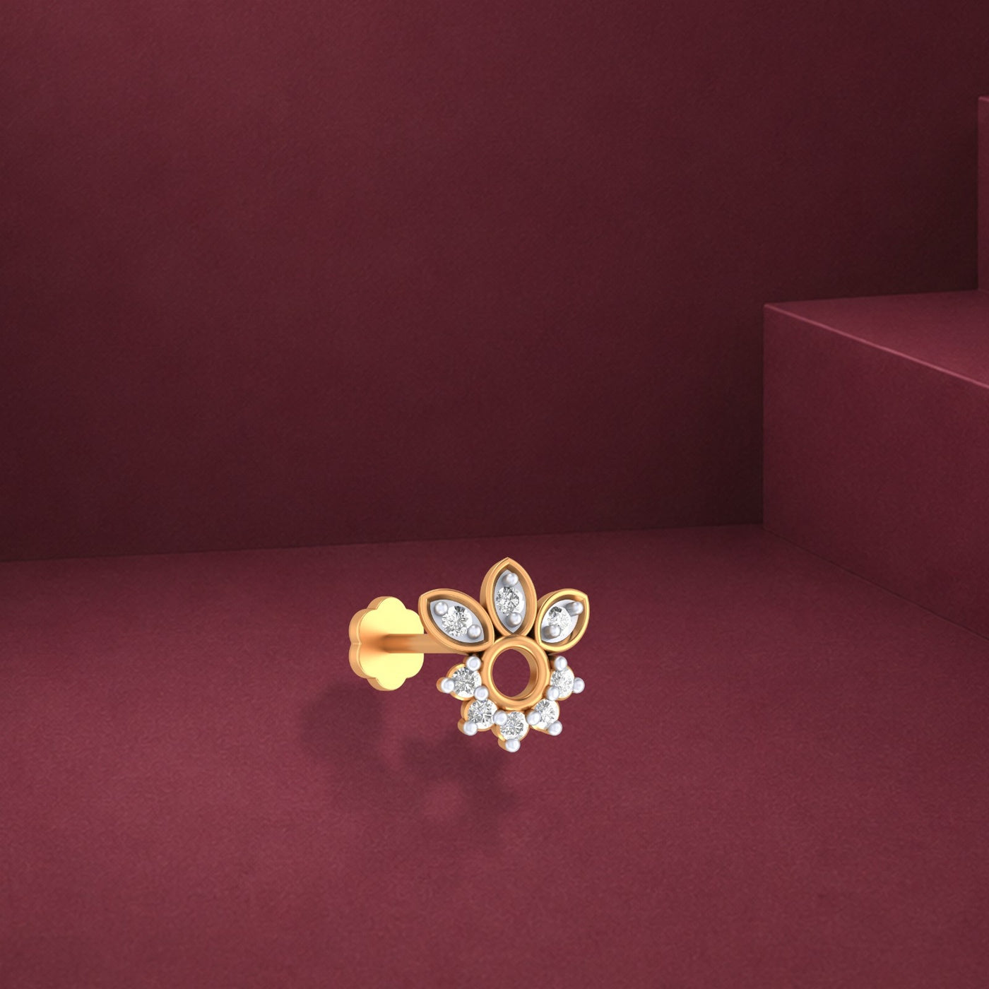 Elegant yellow gold and diamond floral nose pin with sparkling accents on a burgundy background.