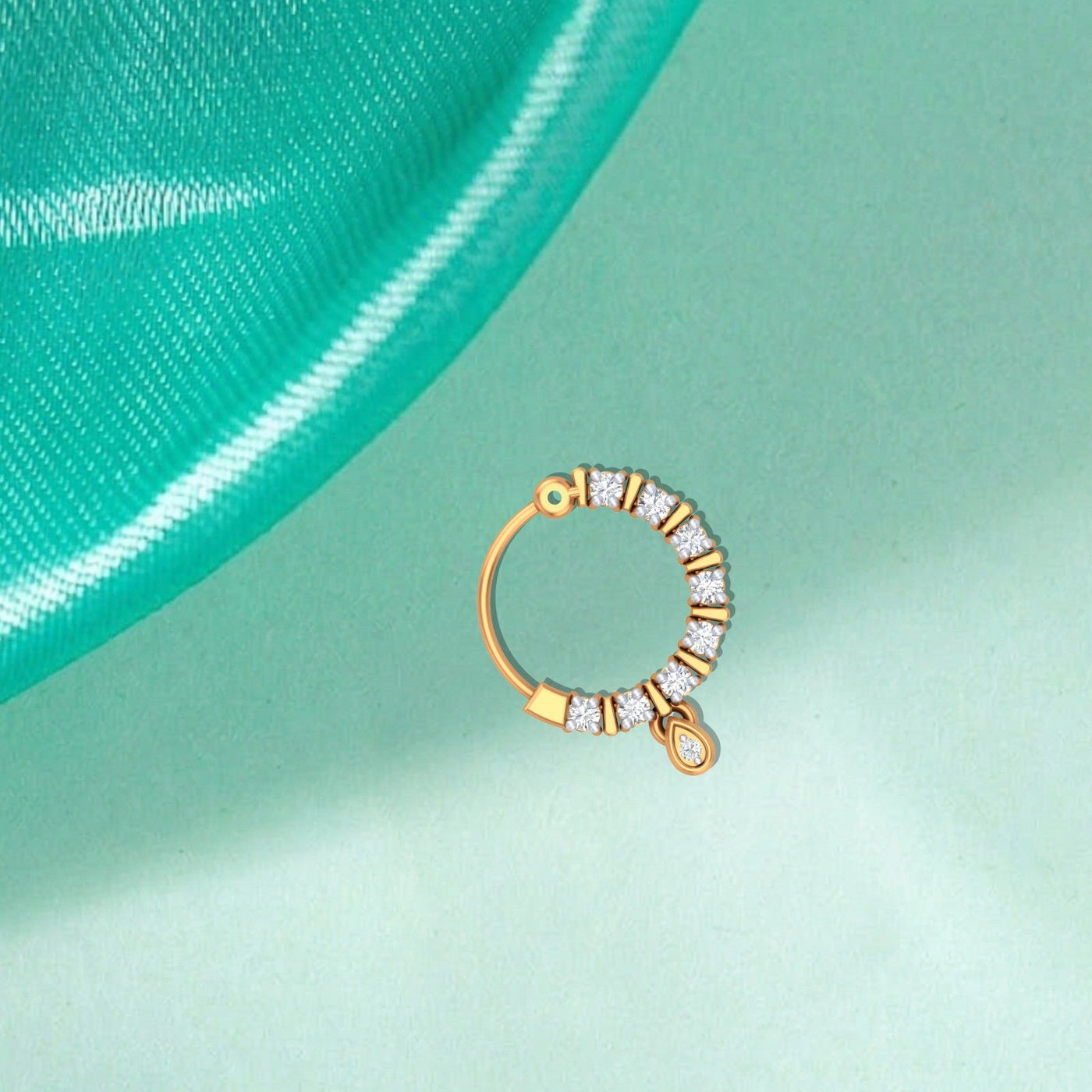 YellowGold and diamond nose ring on a teal background