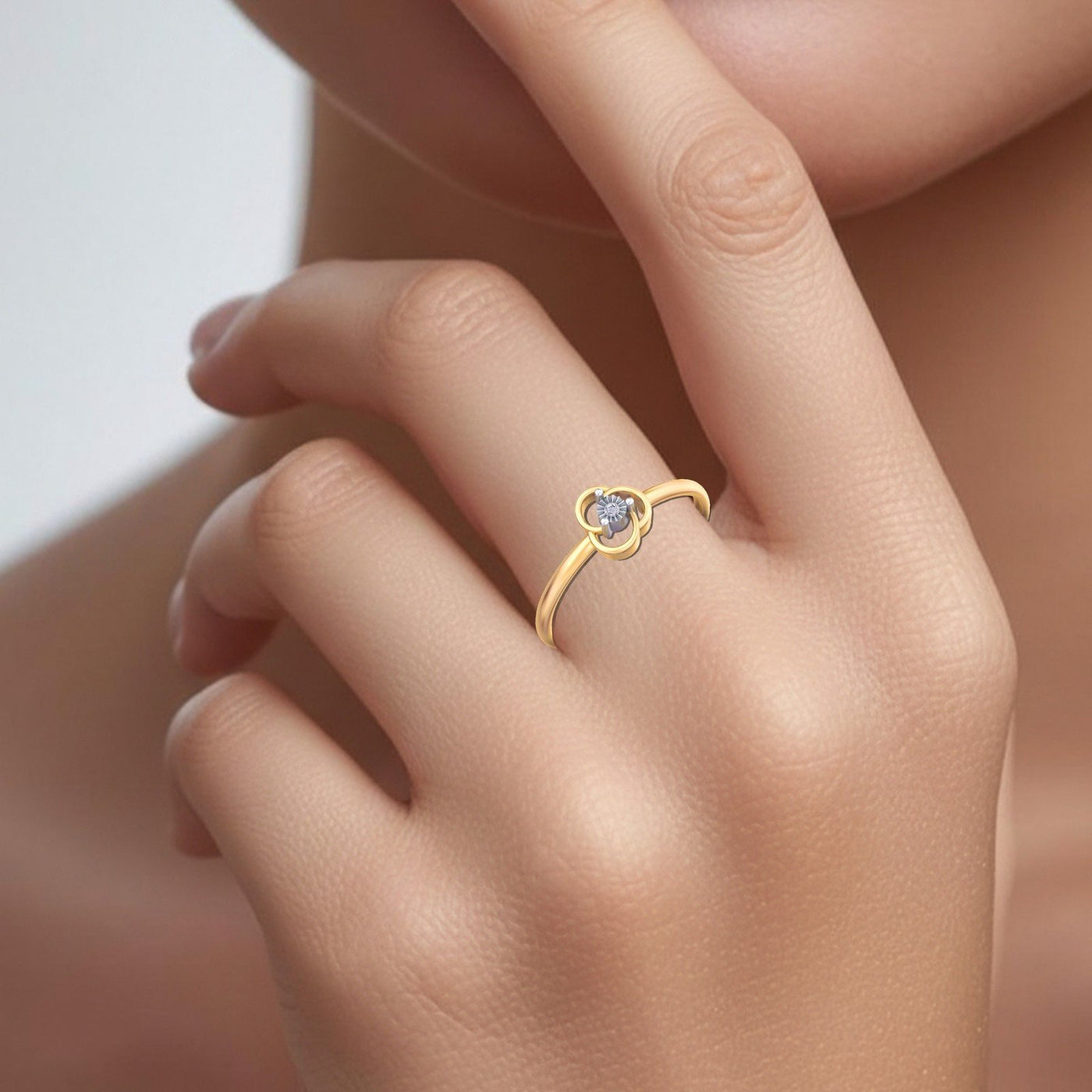 Gold and diamond with floral-design on a person's finger.