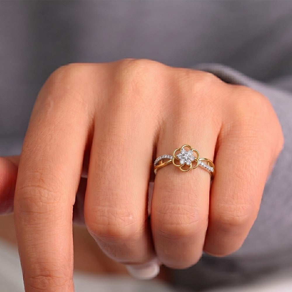 Close-up of a hand wearing two gold rings with diamond accents on a neutral background