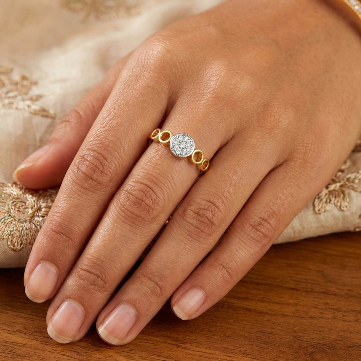 Gold and diamond with cluster setting on a person's finger.