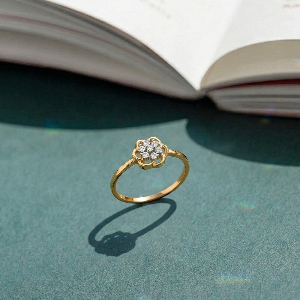 Gold and diamond with floral cluster setting on a green surface.