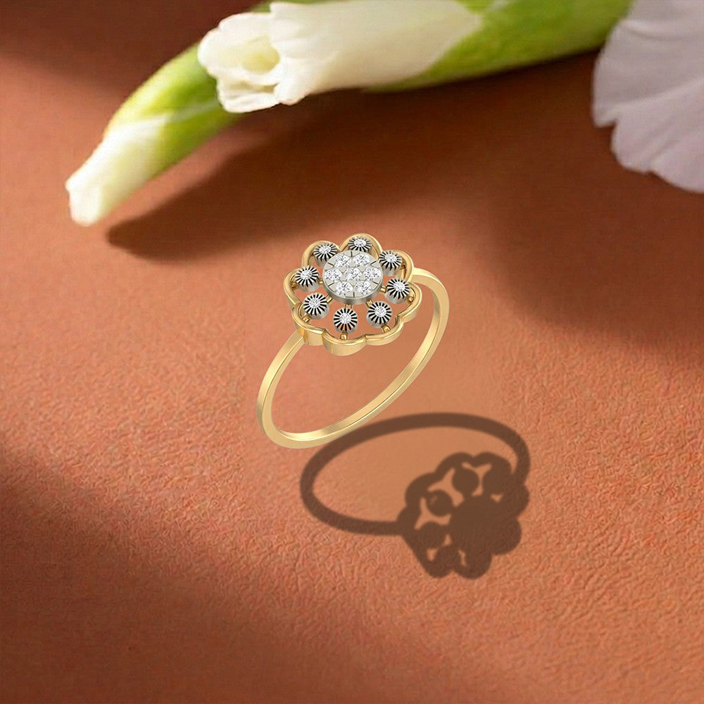 A gold floral-shaped ring with a clear round center cluster setting on a warm brown surface.