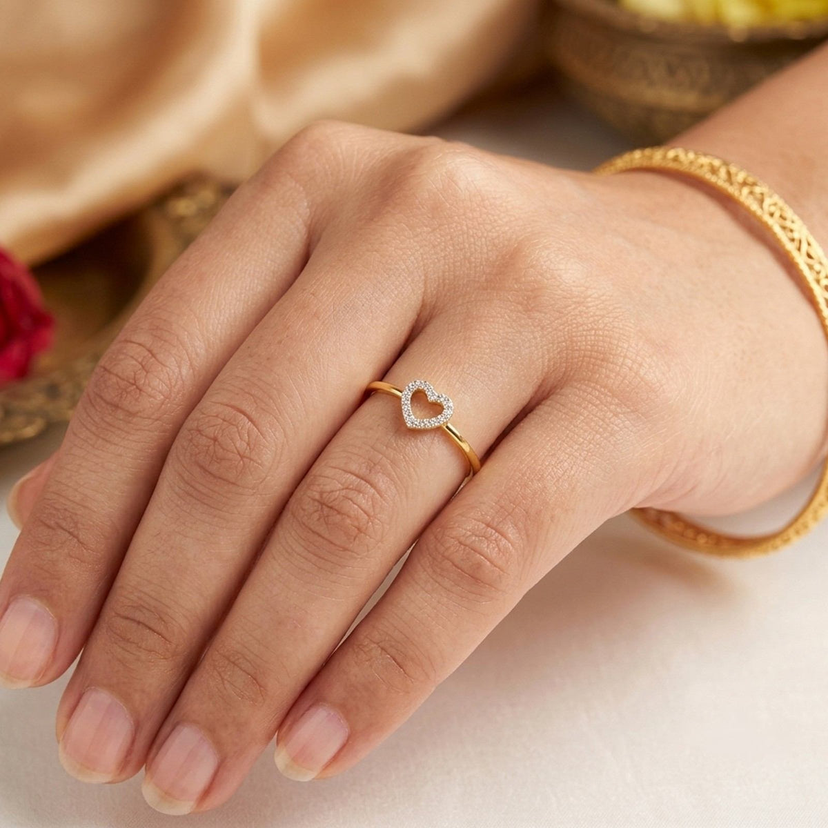A delicate yellow gold ring featuring a heart-shaped ring