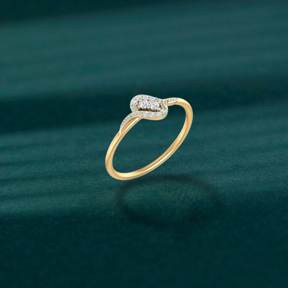 A gold and diamond ring, resting on a dark teal textured surface.