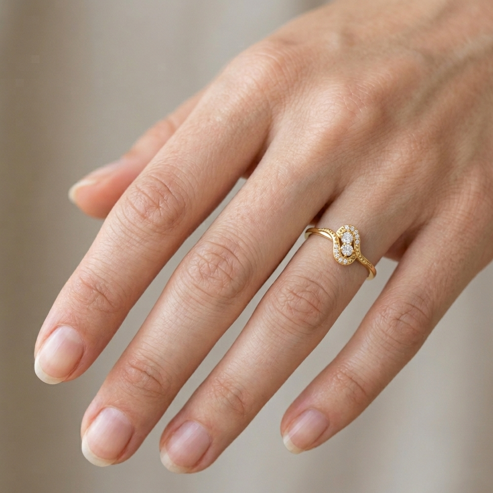 Hand wearing a gold ring with a diamond on a blurred background