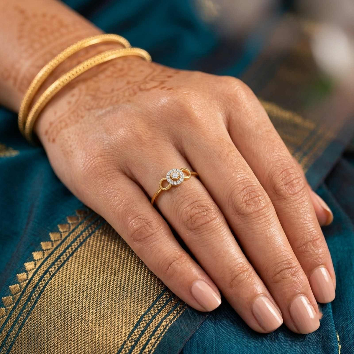 Gold and diamond with halo diamond setting on a person's finger.