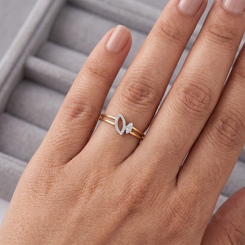 A close-up of a hand wearing a delicate double-band ring. 