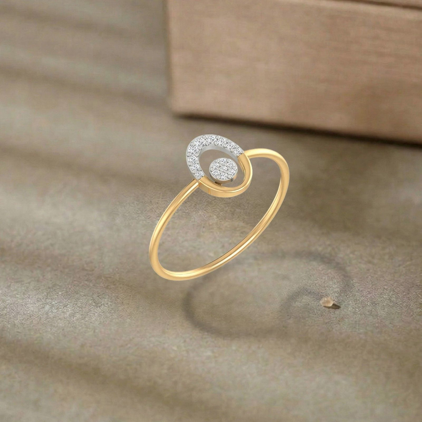 Gold and diamond ring with diamond accents on a brown surface.