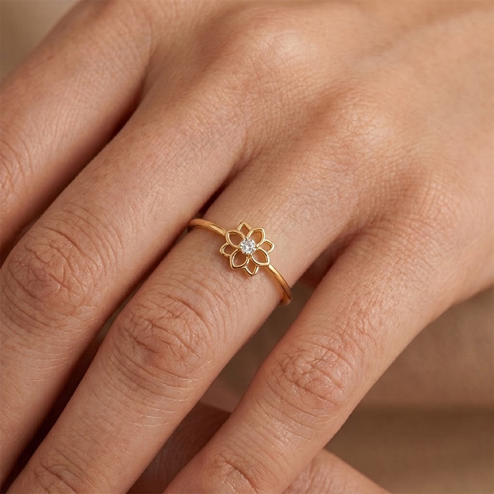 Gold ring with a diamond on a person's finger against a neutral background

