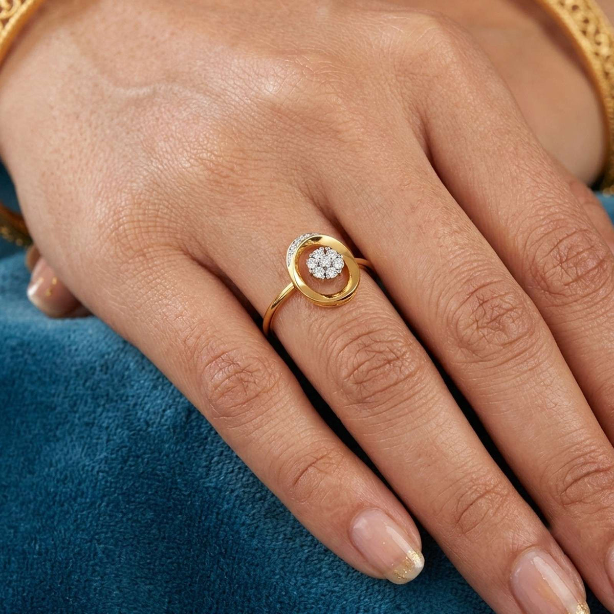 Gold and diamond with center floral cluster on a person's finger.